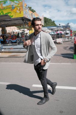 Güzel, siyah saçlı İtalyan çocuk terk edilmiş lunaparkta yürüyor. Yüksek kalite fotoğraf