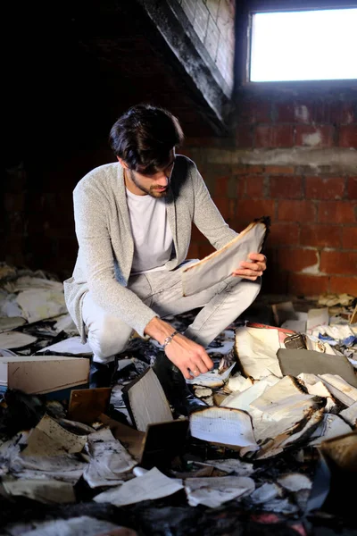 Güzel, siyah saçlı İtalyan çocuk yanmış dökümanları topluyor. Yüksek kalite fotoğraf