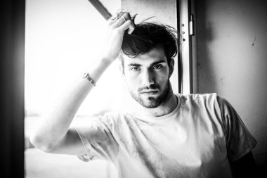 Vitrindeki siyah saçlı, güzel İtalyan tişörtlü adam. Yüksek kalite fotoğraf