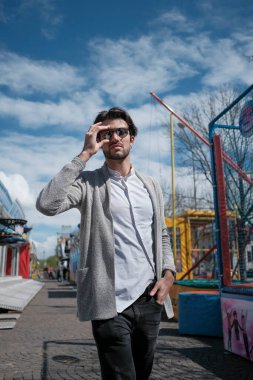 Güzel, siyah saçlı İtalyan çocuk terk edilmiş lunaparkta yürüyor. Yüksek kalite fotoğraf