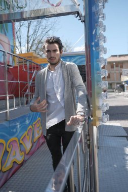 Güzel, siyah saçlı İtalyan çocuk terk edilmiş lunaparkta yürüyor. Yüksek kalite fotoğraf