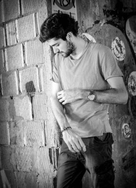 Güzel, siyah saçlı İtalyan çocuk inşaat halindeki fabrikada yürüyor. Yüksek kalite fotoğraf