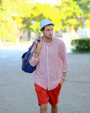 Yakışıklı, koyu renk saçlı, şapkalı ve çizgili gömlekli bir İtalyan. Yüksek kalite fotoğraf