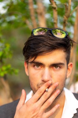 Yakışıklı, koyu renk saçlı İtalyan çocuk sigara içiyor. Yüksek kalite fotoğraf