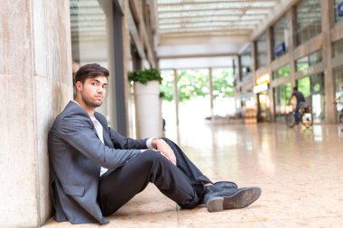 yakışıklı, siyah saçlı, mermer zeminde oturan adam. Yüksek kalite fotoğraf