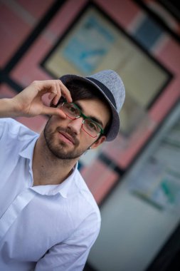 Yakışıklı, siyah saçlı, şapkalı ve gözlüklü bir İtalyan. Yüksek kalite fotoğraf