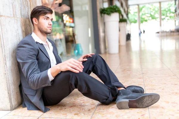 yakışıklı, siyah saçlı, mermer zeminde oturan adam. Yüksek kalite fotoğraf