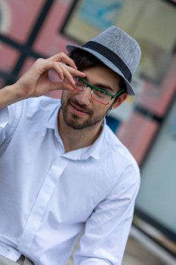 handsome Italian dark-haired guy with hat and eyeglasses. High quality photo