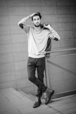 Uzun bir binanın çatısındaki yakışıklı, siyah saçlı adam. Yüksek kalite fotoğraf