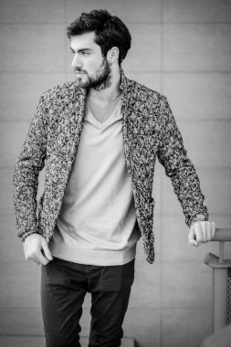 Uzun bir binanın çatısındaki yakışıklı, siyah saçlı adam. Yüksek kalite fotoğraf