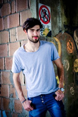 Dejenere olmuş terk edilmiş fabrikadaki yakışıklı siyah saçlı İtalyan adam. Yüksek kalite fotoğraf