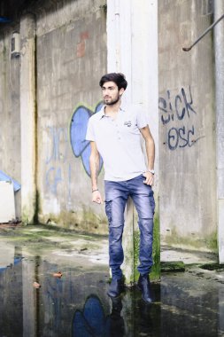 Dejenere olmuş terk edilmiş fabrikadaki yakışıklı siyah saçlı İtalyan adam. Yüksek kalite fotoğraf