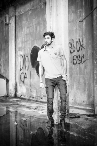 Dejenere olmuş terk edilmiş fabrikadaki yakışıklı siyah saçlı İtalyan adam. Yüksek kalite fotoğraf