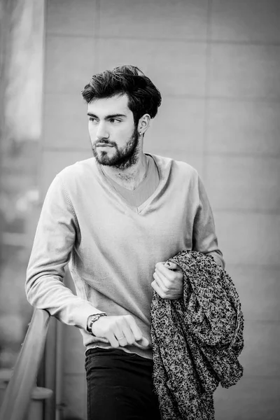 Uzun bir binanın çatısındaki yakışıklı, siyah saçlı adam. Yüksek kalite fotoğraf