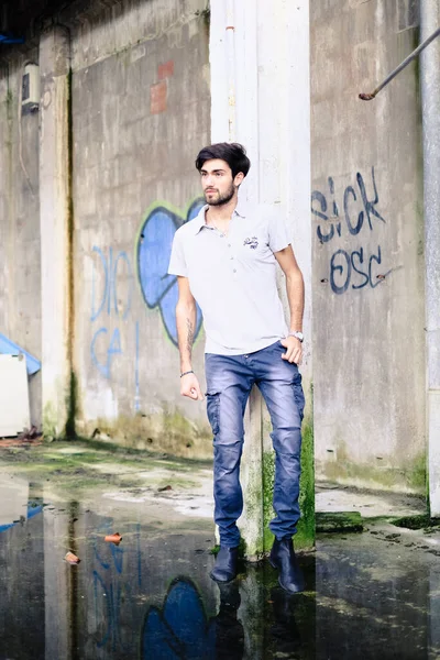 Dejenere olmuş terk edilmiş fabrikadaki yakışıklı siyah saçlı İtalyan adam. Yüksek kalite fotoğraf