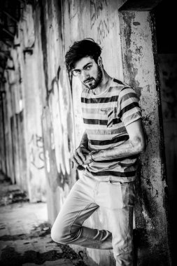 Dejenere olmuş terk edilmiş fabrikadaki yakışıklı siyah saçlı İtalyan adam. Yüksek kalite fotoğraf