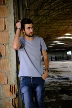 Güzel, siyah saçlı İtalyan çocuk inşaat halindeki fabrikada yürüyor. Yüksek kalite fotoğraf