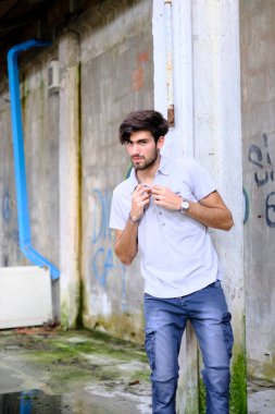 Dejenere olmuş terk edilmiş fabrikadaki yakışıklı siyah saçlı İtalyan adam. Yüksek kalite fotoğraf