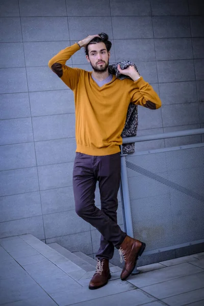 Uzun bir binanın çatısındaki yakışıklı, siyah saçlı adam. Yüksek kalite fotoğraf