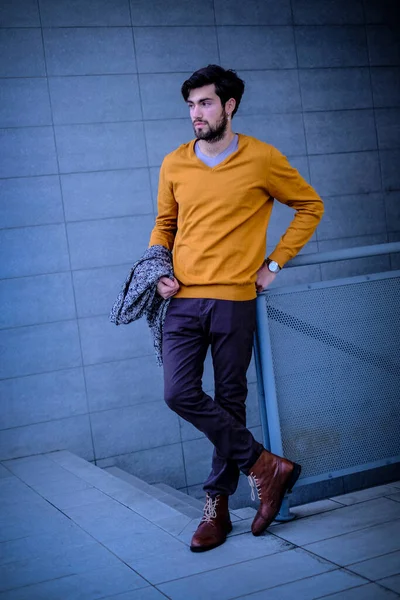 Uzun bir binanın çatısındaki yakışıklı, siyah saçlı adam. Yüksek kalite fotoğraf