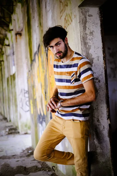 Dejenere olmuş terk edilmiş fabrikadaki yakışıklı siyah saçlı İtalyan adam. Yüksek kalite fotoğraf