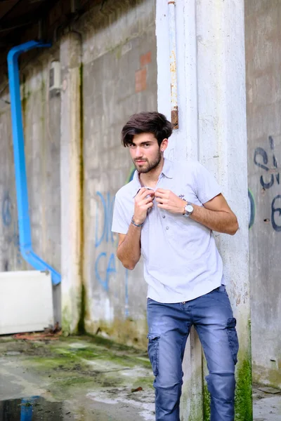 Dejenere olmuş terk edilmiş fabrikadaki yakışıklı siyah saçlı İtalyan adam. Yüksek kalite fotoğraf