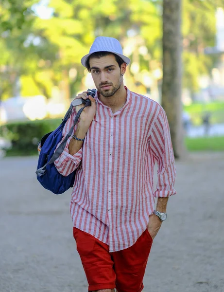 Yakışıklı, koyu renk saçlı, şapkalı ve çizgili gömlekli bir İtalyan. Yüksek kalite fotoğraf