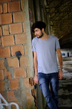 Güzel, siyah saçlı İtalyan çocuk inşaat halindeki fabrikada yürüyor. Yüksek kalite fotoğraf