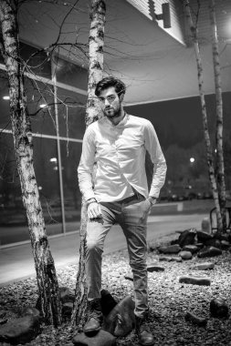 Yakışıklı, siyah saçlı İtalyan çocuk akşam şehir merkezinde yürüyor. Yüksek kalite fotoğraf