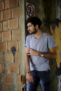 Güzel, siyah saçlı İtalyan çocuk inşaat halindeki fabrikada yürüyor. Yüksek kalite fotoğraf