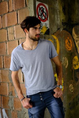 Güzel, siyah saçlı İtalyan çocuk inşaat halindeki fabrikada yürüyor. Yüksek kalite fotoğraf