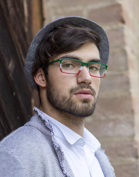 Yakışıklı, siyah saçlı, zarif şapkalı ve gözlüklü bir İtalyan. Yüksek kalite fotoğraf