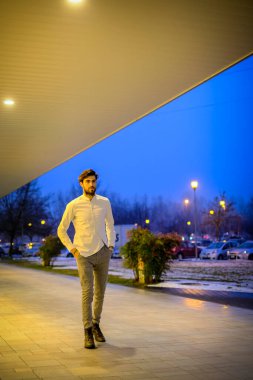 Yakışıklı, siyah saçlı İtalyan çocuk akşam şehir merkezinde yürüyor. Yüksek kalite fotoğraf