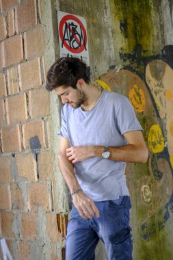 Güzel, siyah saçlı İtalyan çocuk inşaat halindeki fabrikada yürüyor. Yüksek kalite fotoğraf