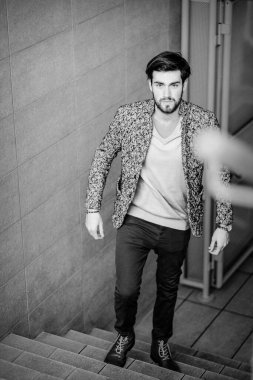 Uzun bir binanın çatısındaki yakışıklı, siyah saçlı adam. Yüksek kalite fotoğraf