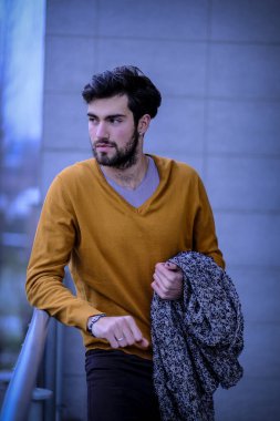 Uzun bir binanın çatısındaki yakışıklı, siyah saçlı adam. Yüksek kalite fotoğraf