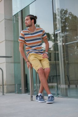 Yakışıklı, siyah saçlı bir İtalyan metal korkuluklarda oturuyor. Yüksek kalite fotoğraf