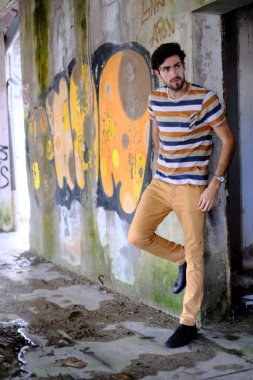 Dejenere olmuş terk edilmiş fabrikadaki yakışıklı siyah saçlı İtalyan adam. Yüksek kalite fotoğraf