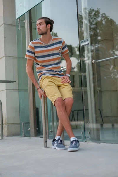 Yakışıklı, siyah saçlı bir İtalyan metal korkuluklarda oturuyor. Yüksek kalite fotoğraf