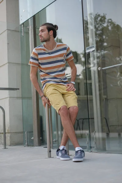 Yakışıklı, siyah saçlı bir İtalyan metal korkuluklarda oturuyor. Yüksek kalite fotoğraf