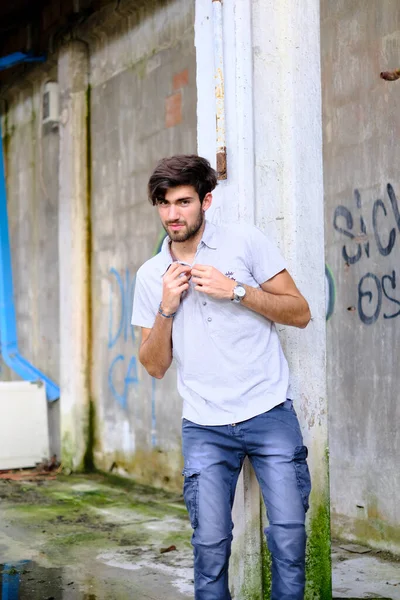 Dejenere olmuş terk edilmiş fabrikadaki yakışıklı siyah saçlı İtalyan adam. Yüksek kalite fotoğraf