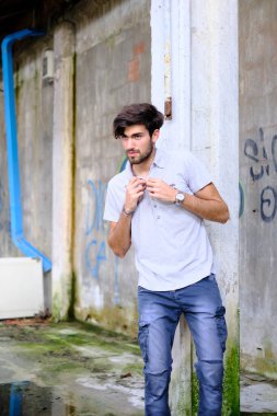 Dejenere olmuş terk edilmiş fabrikadaki yakışıklı siyah saçlı İtalyan adam. Yüksek kalite fotoğraf