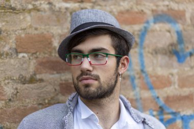 Yakışıklı, siyah saçlı, şapkalı ve gözlüklü bir İtalyan. Yüksek kalite fotoğraf
