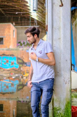 Dejenere olmuş terk edilmiş fabrikadaki yakışıklı siyah saçlı İtalyan adam. Yüksek kalite fotoğraf