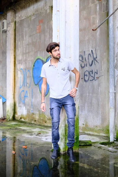 Dejenere olmuş terk edilmiş fabrikadaki yakışıklı siyah saçlı İtalyan adam. Yüksek kalite fotoğraf