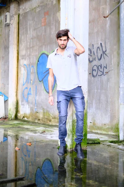 Dejenere olmuş terk edilmiş fabrikadaki yakışıklı siyah saçlı İtalyan adam. Yüksek kalite fotoğraf