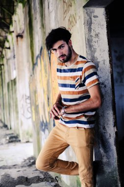 Dejenere olmuş terk edilmiş fabrikadaki yakışıklı siyah saçlı İtalyan adam. Yüksek kalite fotoğraf