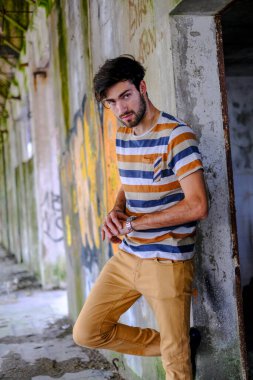 Dejenere olmuş terk edilmiş fabrikadaki yakışıklı siyah saçlı İtalyan adam. Yüksek kalite fotoğraf