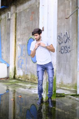 Dejenere olmuş terk edilmiş fabrikadaki yakışıklı siyah saçlı İtalyan adam. Yüksek kalite fotoğraf