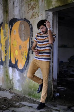 Dejenere olmuş terk edilmiş fabrikadaki yakışıklı siyah saçlı İtalyan adam. Yüksek kalite fotoğraf